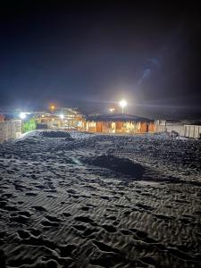 uma praia de areia à noite com luzes acesas em Vistazul em Vichayito