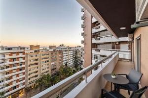 - un balcon avec une table, des chaises et des bâtiments dans l'établissement Faro Main Avenue Apartment, à Faro
