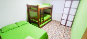 a bedroom with a green bed and a bunk room at Hostal mis dos ángeles in Santiago
