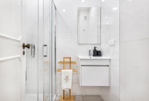 bagno bianco con doccia e lavandino di Faro Main Avenue Apartment a Faro