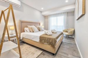 a bedroom with a large bed and a chair at Faro Main Avenue Apartment in Faro