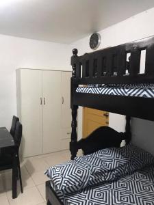 1 dormitorio con litera negra y silla en RV3 TRANSIENT HOUSE en Ángeles