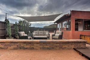 a patio with couches and chairs on a brick wall at Beautiful Sedona Home Near Chapel of the Holy Cross in Sedona