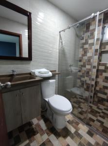 y baño con aseo, lavabo y ducha. en Hotel Kai Soledad Atlántico, en Soledad