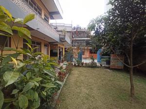 una casa con un cortile di fronte a un edificio di Pushpa Guest House a Pokhara