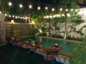 a pool with tables and chairs next to a swimming pool at Baan Soksan in Siem Reap