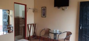 Zimmer mit einem Tisch, Stühlen und einem TV in der Unterkunft Motel Sahara Suites in Barranca