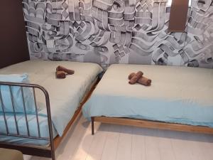 2 Betten in einem Zimmer mit Handtüchern darauf in der Unterkunft AOCA Kaminoge 501 in Tokio