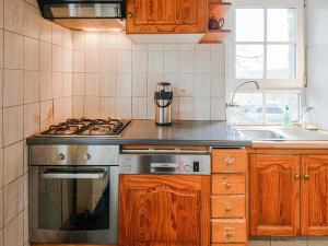 a kitchen with a stove and a sink at Cozy farmhouse in Brisy with sauna 