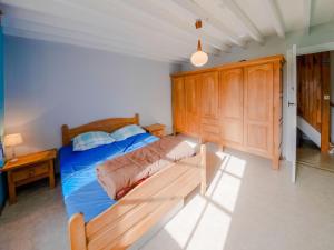 a bedroom with a bed and a wooden cabinet at Cozy farmhouse in Brisy with sauna 