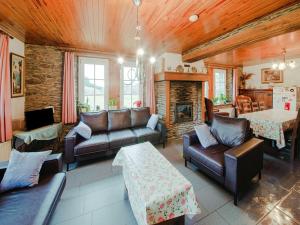 a living room with leather furniture and a fireplace at Cozy farmhouse in Brisy with sauna 