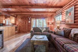 una sala de estar con sofás y una mesa en una cabaña de madera en Woodsy Wonder, en Tahoe City