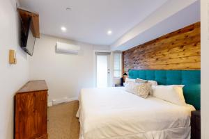 a bedroom with a large bed and a wooden wall at Market Place Lodge 249 in Whistler +8 photos