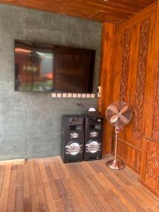 a room with a fan and a television on a wooden floor at Villa SB Pacet in Sajen