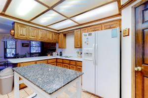 een keuken met houten kasten en een witte koelkast bij The Dragonfly in South Fork
