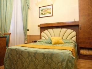 a bedroom with a bed with a yellow pillow on it at Atlantide Hotel in Venice