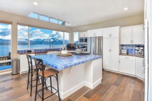 a kitchen with white cabinets and a table with stools at Moosewood Haven - Ideal Lakeside Retreat in Sagle +26 photos