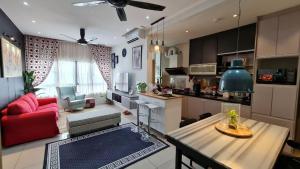 a kitchen and a living room with a red couch at H&H Bangi Sentral Suites in Bangi