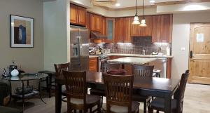 een keuken met een tafel en stoelen en een koelkast bij Luxurious Condo, Sleeps 8 - Silver Mtn #207 in Bear Valley