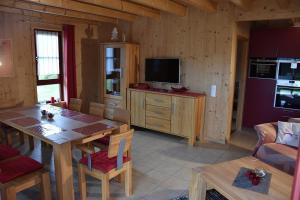 cocina y comedor con mesa y TV en Ferienhaus Nr 5C plus, Feriendorf Hagbügerl, Bayr Wald en Waldmünchen