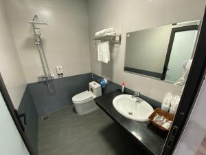W łazience znajduje się umywalka, toaleta i lustro. w obiekcie Hotel A18 Lào Cai w mieście Lao Cai