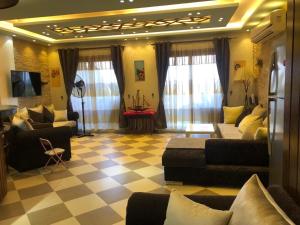 sala de estar con sofás y suelo a cuadros en New Panorama Sea View Villa Family, en Ain Sokhna