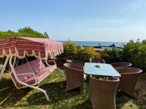 アインソフナにあるNew Panorama Sea View Villa Familyのテーブル、椅子、パラソル、テーブル、椅子が備わります。