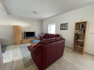 a living room with a couch and a tv at Ferienhaus am Baybach in Burgen an der Mosel in Burgen