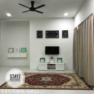 a living room with a ceiling fan and a television at Stayz Guesthouse in Sungkai