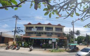 een gebouw met motoren die ervoor geparkeerd staan bij P & T Hostel in Bangrak Beach