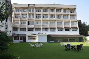 un bâtiment avec des tables et des chaises devant lui dans l'établissement Cardinal Ambica, à Katra