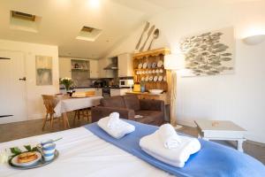 cocina y sala de estar con mesa y toallas en East Green Farm Cottage - Studio Barn - Aldeburgh Coastal Cottages en Kelsale