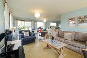uma sala de estar com um sofá e uma mesa em Sea Poppies em Thorpeness