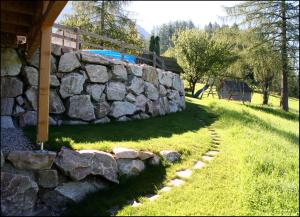 a stone wall next to a yard with a playground at Kalßnhof in Bad Aussee