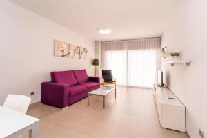 ein Wohnzimmer mit einem lila Sofa und einem Tisch in der Unterkunft Vistamar Luxury Apartments By DLV -Adults Only- in Villajoyosa + 75 Fotos