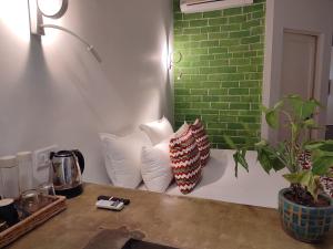 dos almohadas sentadas en un mostrador con una pared de ladrillo verde en Mukam, Boutique Homestay en Jaipur