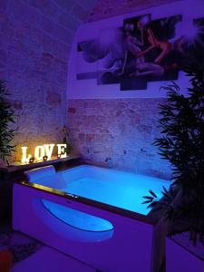 a bath tub in a room with purple lights at Suite dream room in Turi