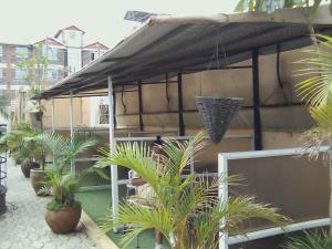 um pátio com um guarda-chuva preto e algumas plantas em Luna hotel em Nakuru