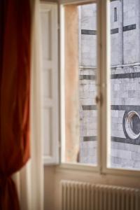 una ventana con vistas a una pared de ladrillo en Palazzo del Magnifico B&B, en Siena