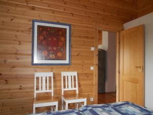 ein Schlafzimmer mit 2 Stühlen und einem Gemälde an der Wand in der Unterkunft Tornvillan in Hammarland