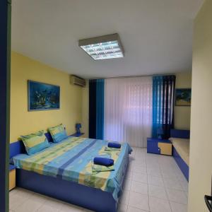 a bedroom with a bed with a blue comforter at GALA APARTMENT in Veliko Tŭrnovo