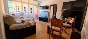 a living room with a table and a television at Fenals Beach & Pool in Lloret de Mar