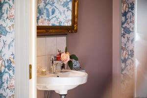 a white sink sitting under a mirror in a bathroom at Strandvillan Hotell och Bed & Breakfast in Lysekil