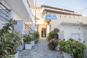 a building with potted plants in front of it at Psiloritis Elena in Kalamaki