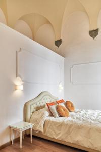 een bed met 2 kussens en een tafel in een kamer bij Palazzo del Magnifico B&B in Siena