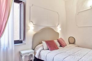 1 dormitorio con 1 cama con 2 almohadas rosas en Palazzo del Magnifico B&B, en Siena