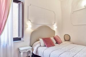a bedroom with a white bed and white walls at Palazzo del Magnifico B&B in Siena