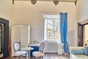 sala de estar con mesa, sillas y ventana en Palazzo del Magnifico B&B, en Siena