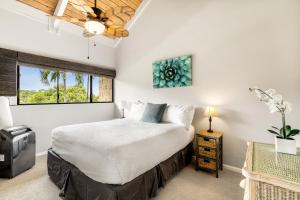 ein Schlafzimmer mit einem Bett und einem Fenster in der Unterkunft Keauhou Punahele B301 in Kailua-Kona