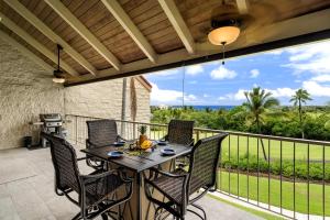 a patio with a table and chairs on a balcony at Keauhou Punahele B301 in Kailua-Kona
